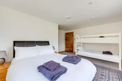 a bedroom with a large white bed with two towels on it at 6 Bed in Barmouth oc-bow245 in Fairbourne