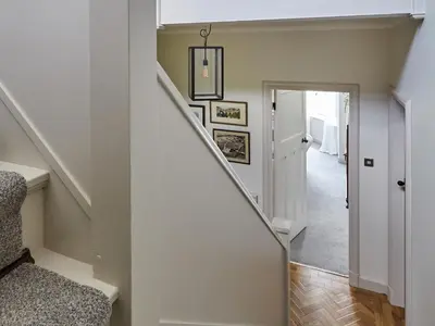 a staircase in a home with white walls and wood floors at Green Acres in Llangollen