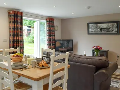 a living room with a table and a couch at Llain Cottage in Llanina
