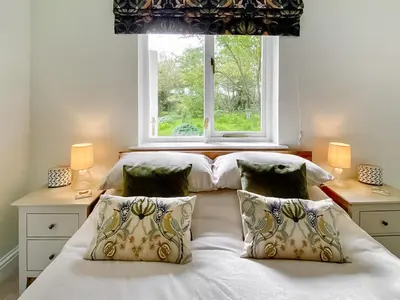 a bedroom with two beds and a window at Rose Cottage in Blakemere
