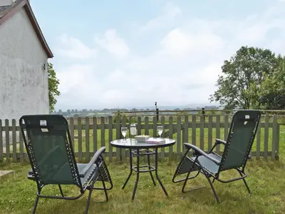 two chairs and a table in a yard with a fence at Uk34913 - Bwlchgraig Fach in Nantcwnlle