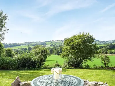 a glass vase sitting on a table in a field at Pentre Cwm Bach in Llansilin