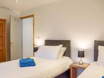 a bedroom with two beds and a mirror at Llety'r Saer in Pen-y-bont-fawr
