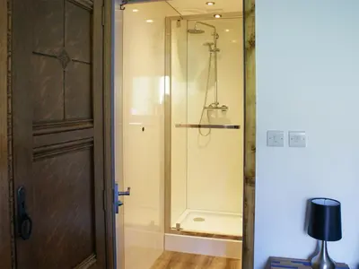 a bathroom with a shower and a glass door at Llety'r Saer in Pen-y-bont-fawr