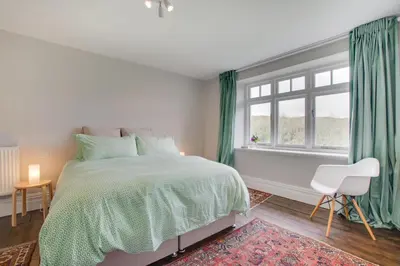 a white bedroom with a bed and a window at 4 Bed in Barmouth oc-bow259 in Barmouth
