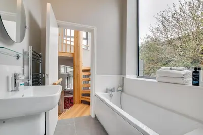 a bathroom with a tub and a sink and a window at 4 Bed in Barmouth oc-bow259 in Barmouth