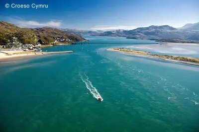 a boat in the water next to a beach at 4 Bed in Barmouth oc-bow259 in Barmouth
