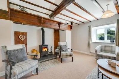 a living room with a fireplace and two chairs at 4 Bed in Welshpool oc-wab267 in Welshpool