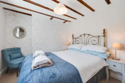 a bedroom with a bed and a blue chair at 4 Bed in Welshpool oc-wab267 in Welshpool