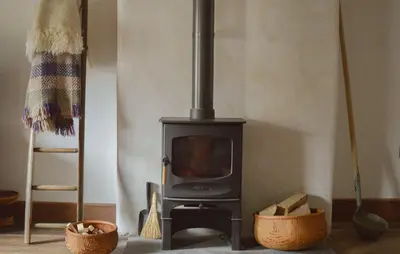 a wood stove in a living room with two baskets at The Pavement Palace in Hay-on-Wye