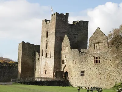 an old castle with a bench in front of it at 55 Corve Street in Ludlow