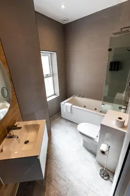 a bathroom with a tub and a toilet and a sink at Ty Belgrave in Aberystwyth