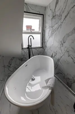 a white bath tub in a bathroom with a window at Ty Belgrave in Aberystwyth