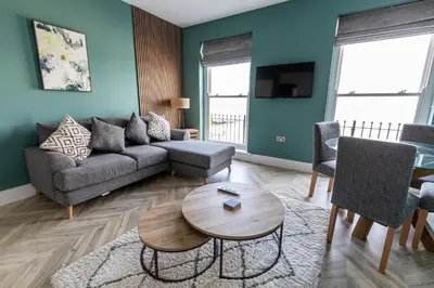 a living room with a couch and a table at Ty Belgrave - Apartment 2 in Aberystwyth