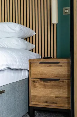 a bedroom with a bed and a night stand with a drawer at Ty Belgrave - Apartment 2 in Aberystwyth