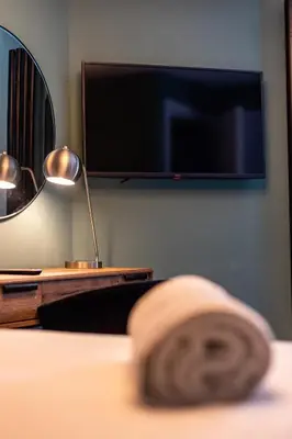 a bedroom with a flat screen tv on a wall at Ty Belgrave - Apartment 3 in Aberystwyth