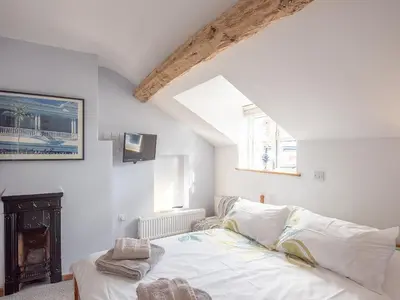 a white bedroom with a bed and a fireplace at Top House in Forden