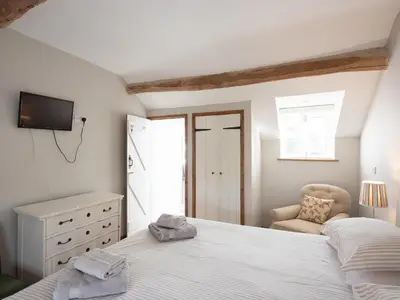a bedroom with a white bed and a chair at Top House in Forden