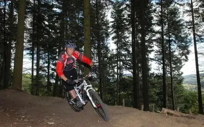 a man riding a bike on a trail in the woods at Eastridge Glamping - Camping Pods in Shrewsbury