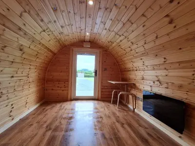 a wooden room with a window and a table in it at Eastridge Glamping - Camping Pods in Shrewsbury