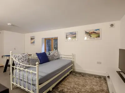a white bedroom with a bed and a window at Hafan Yr Haul in Arthog