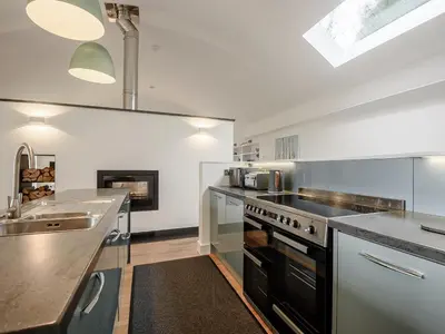 a kitchen with a sink and a stove top oven at Hafan Yr Haul in Arthog