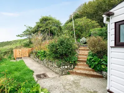 a garden with wooden stairs next to a house at Frondeg in Aberaeron