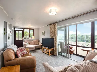 a living room with a couch and a television at Frondeg in Aberaeron
