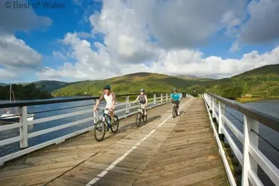 three people riding bikes on a bridge over the water at 1 Bed in Dolgellau oc-bow292 in Dolgellau