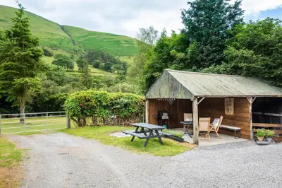 a wooden hut with a picnic table and a picnic bench at 2 Bed in Dinas Mawddwy oc-bow268 in Machynlleth