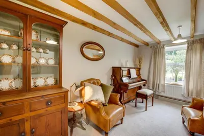 a living room with a china cabinet and a piano at 2 Bed in Dinas Mawddwy oc-bow268 in Machynlleth