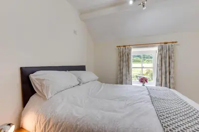a bedroom with a bed and a window at 3 Bed in Tywyn oc-bow248 in Abergynolwyn