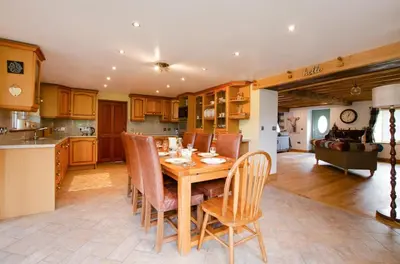 a kitchen and dining room with a wooden table and chairs at 4 Bed in Cray oc-bow288 in Cray