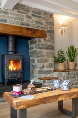 a wooden table with a fireplace in a room at 3 Bed in Aberystwyth oc-bow297 in Pentre-briwnant