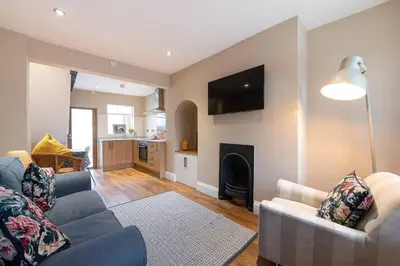a living room with a blue couch and a fireplace at Besford Square, Shrewsbury Town in Shrewsbury
