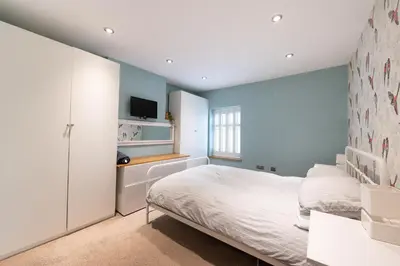 a bedroom with a bed and a tv on a wall at Besford Square, Shrewsbury Town in Shrewsbury