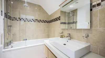a bathroom with a white sink and a bath tub at Stunning Barn Conversion with HOT TUB and ALPACAS - Ty Cerrig Barn in Corwen