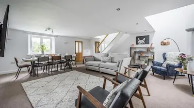 a living room with a couch and a table at Stunning Barn Conversion with HOT TUB and ALPACAS - Ty Cerrig Barn in Corwen