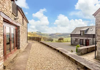a stone house with a view of the hills at Beacons View Farm Cottages in Merthyr Cynog
