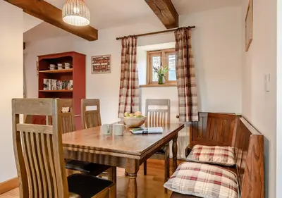 a dining room with a wooden table and chairs at Beacons View Farm Cottages in Merthyr Cynog