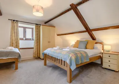 a bedroom with a large bed and a window at Beacons View Farm Cottages in Merthyr Cynog