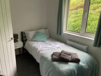 a small bedroom with a bed and a window at 4 bedroom bungalow in peaceful countryside with log burner - Talar Deg, Capel Madog in Capel Madog