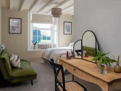 a bedroom with a bed and a desk and a table at Bennar Fawr in Dyffryn