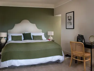 a bedroom with a large bed with a green wall at Bennar Fawr in Dyffryn