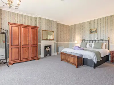 a bedroom with a large bed and a fireplace at Edderton Hall Country House in Welshpool