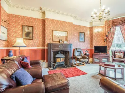 a living room with a couch and a fireplace at Edderton Hall Country House in Welshpool