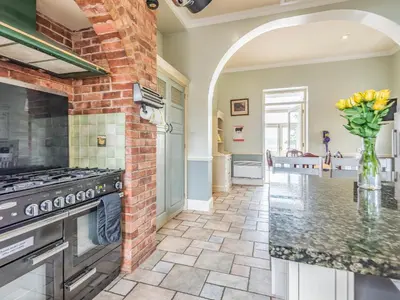 a kitchen with a stove and a brick wall at Edderton Hall Country House in Welshpool