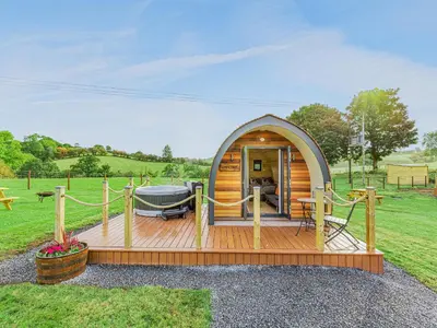 a small wooden cabin with a deck in a field at Oak-Uk36258 in Llanfair Caereinion