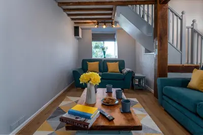 a living room with a couch and a table at Barn Retreat with Valley Views & Onsite Dog Field in Bryn-crug
