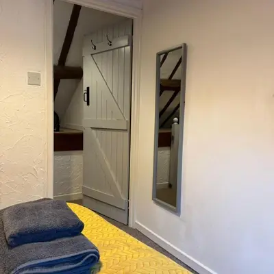 a bathroom with a mirror and a bed with towels at Barn Retreat with Valley Views & Onsite Dog Field in Bryn-crug